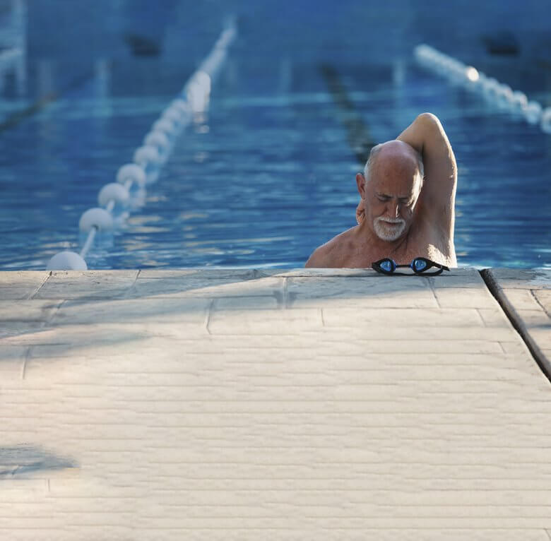 Man stretching after a lap in swimming pool