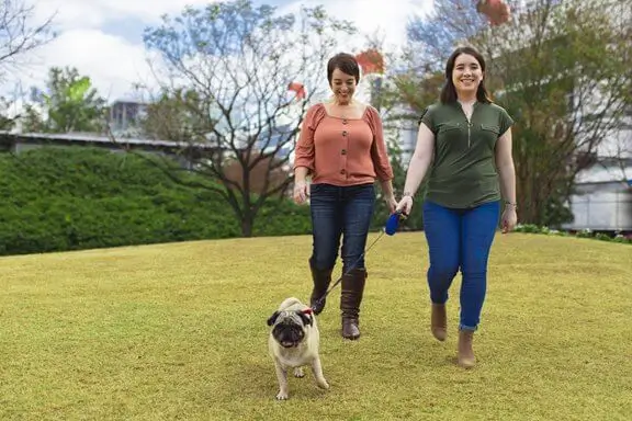 2 women walking dog