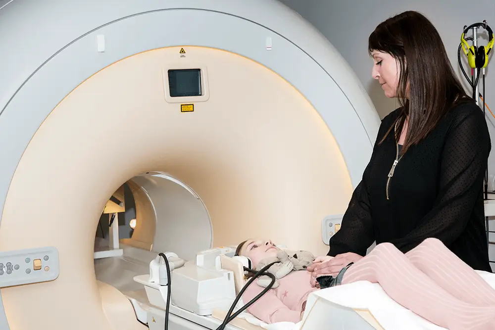 patient in an MRI scanning machine with doctor