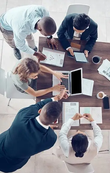 A group of employees gathered around a table while working together