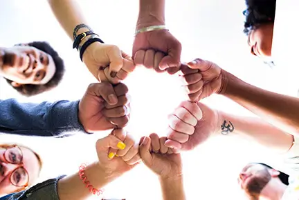 A group of people making a circle with their fists